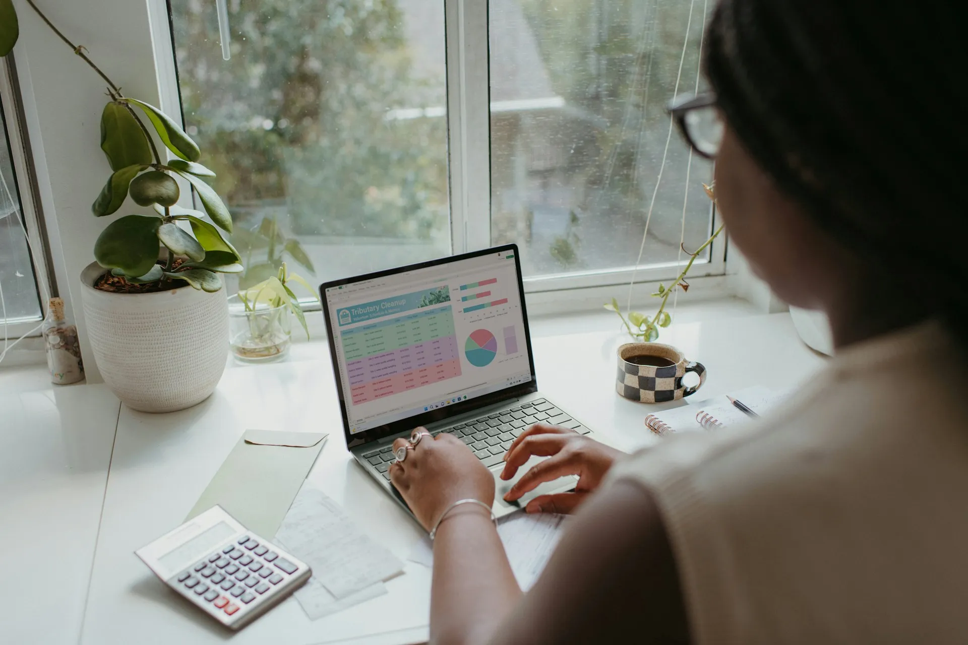 Person analyzing financial charts on computer and smartphone